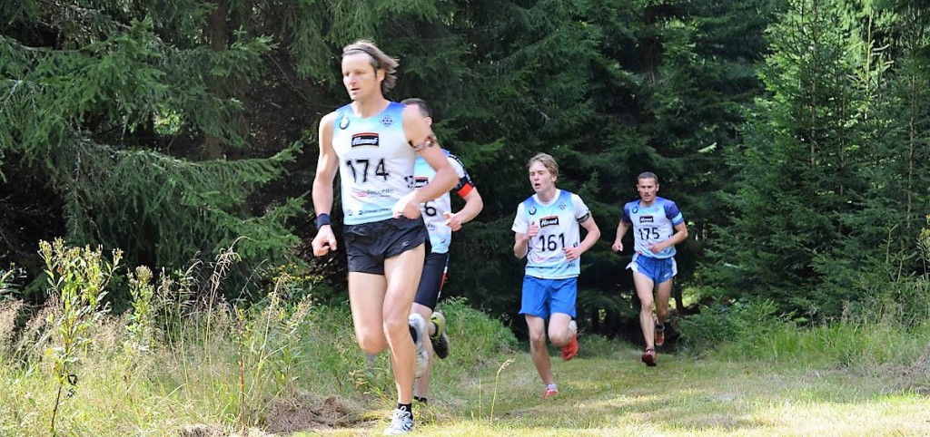 Momentka ze stíhacího závod mužů a juniorů. V popředí Marina Valek z Kapslovny (v cíli nakonec 6.), v zadu Luboš Schorný ze Starého Města pod Landštejnem. Mezi nimi s číslem 11 junior Daniel Krajbich z Roveru Praha.