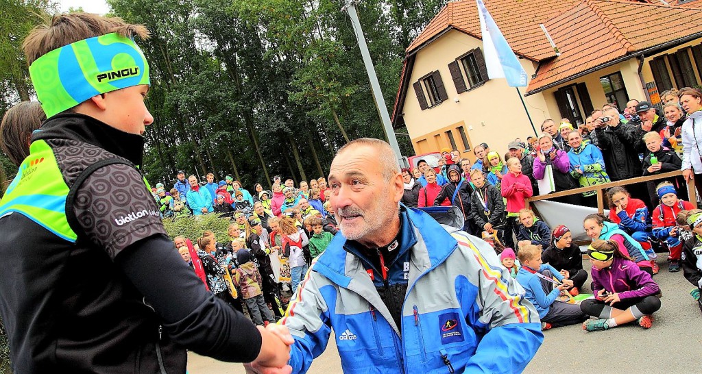 Dekorování nejlepších sledoval zaplněný areál v Šedivském lomu. Nejlepším žákům v závodě s hromadný startem kategorie C právě blahopřeje viceprezident ČSB a šéf rozhodcovské jury Vojtěch Zicháček