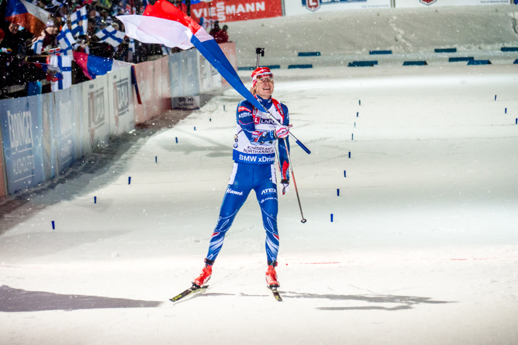 Ondřej Moravec si vychutnává dojezd do cíle se státní vlajkou. Foto: Český biatlon, Petr Slavík